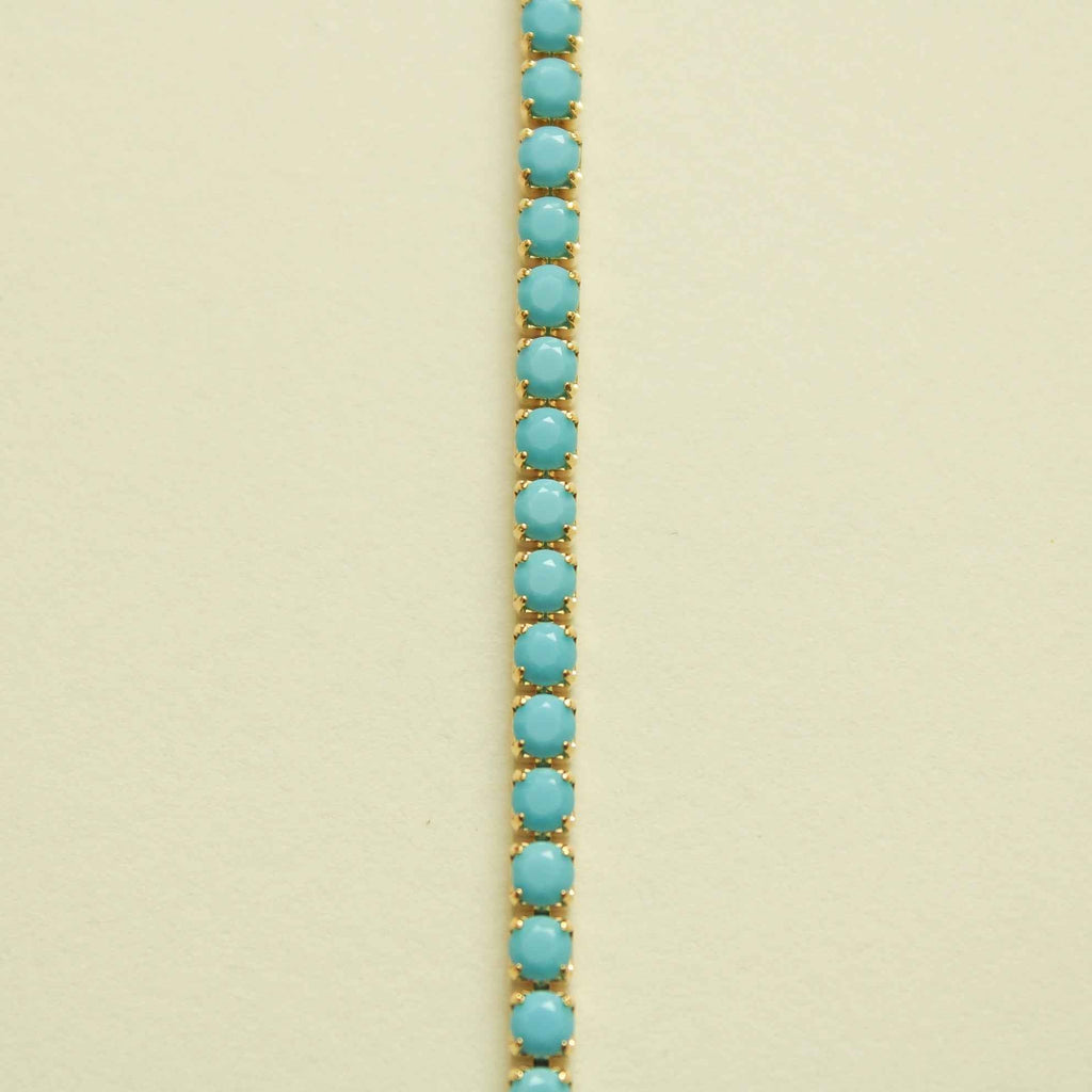 Turquoise beaded tennis bracelet with rows of oval stones on gold setting