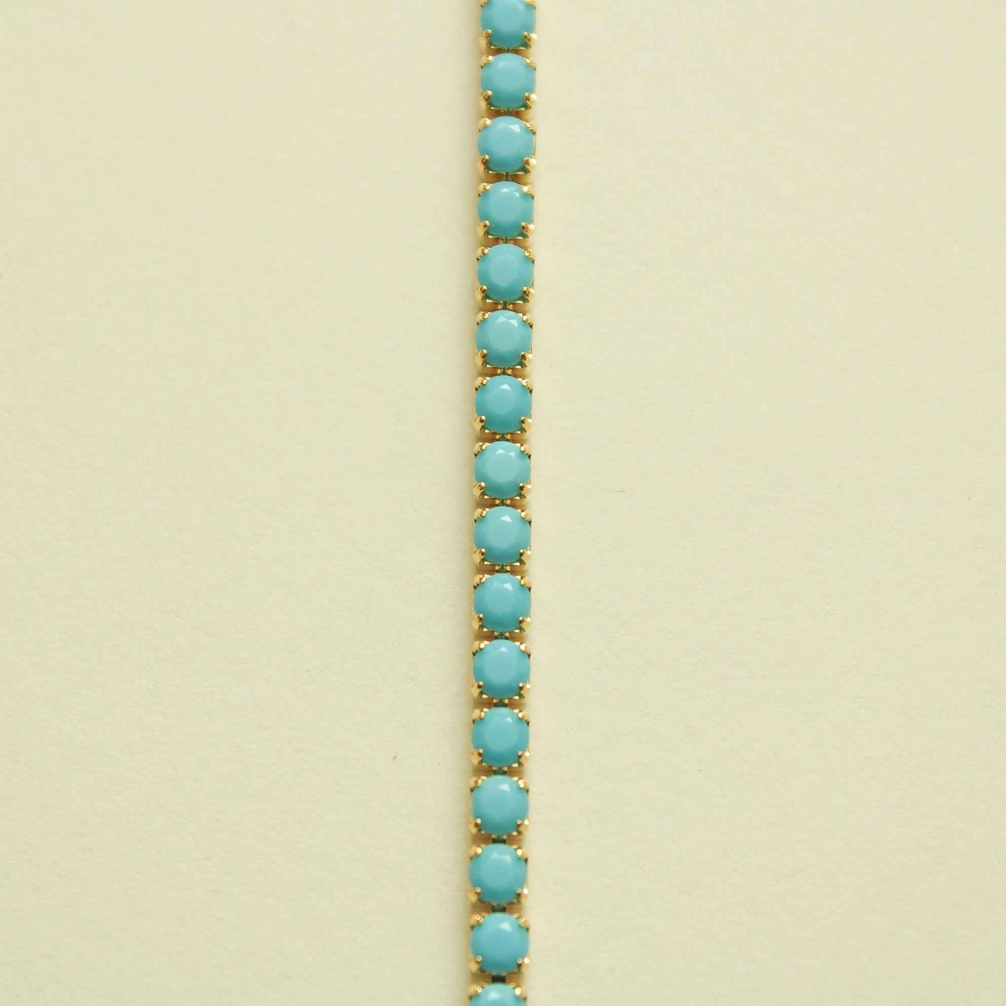 Turquoise beaded tennis bracelet with rows of oval stones on gold setting