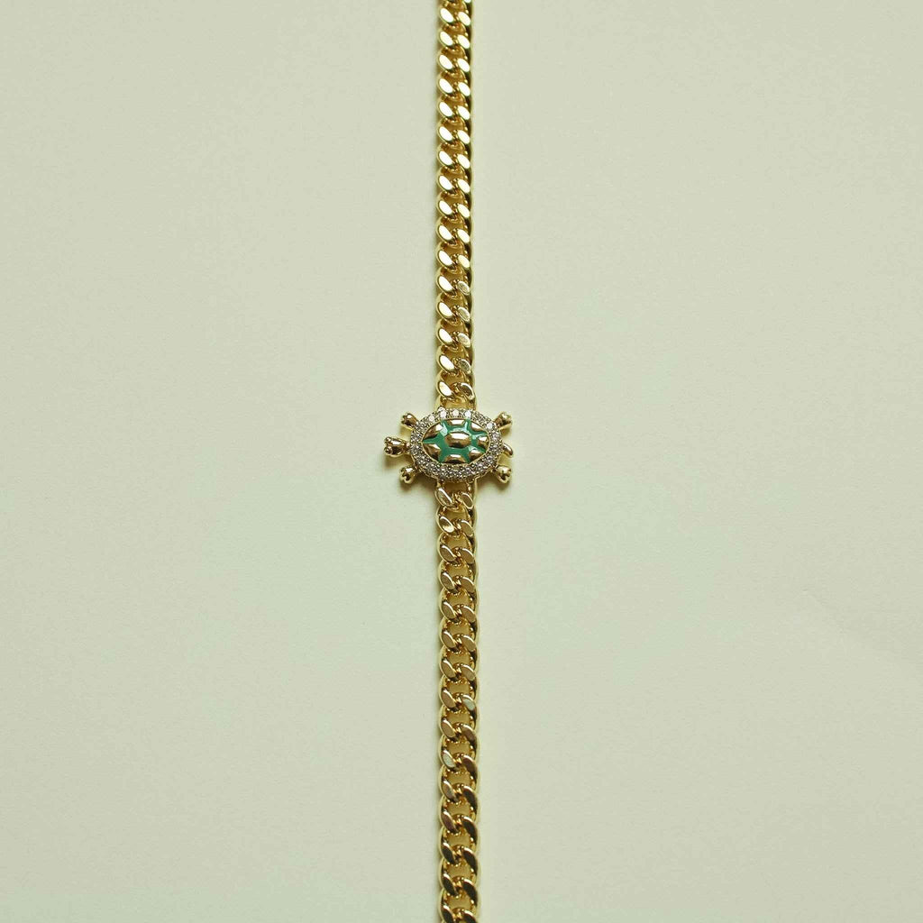Gold turtle charm pendant on Cuban chain necklace with green enamel center