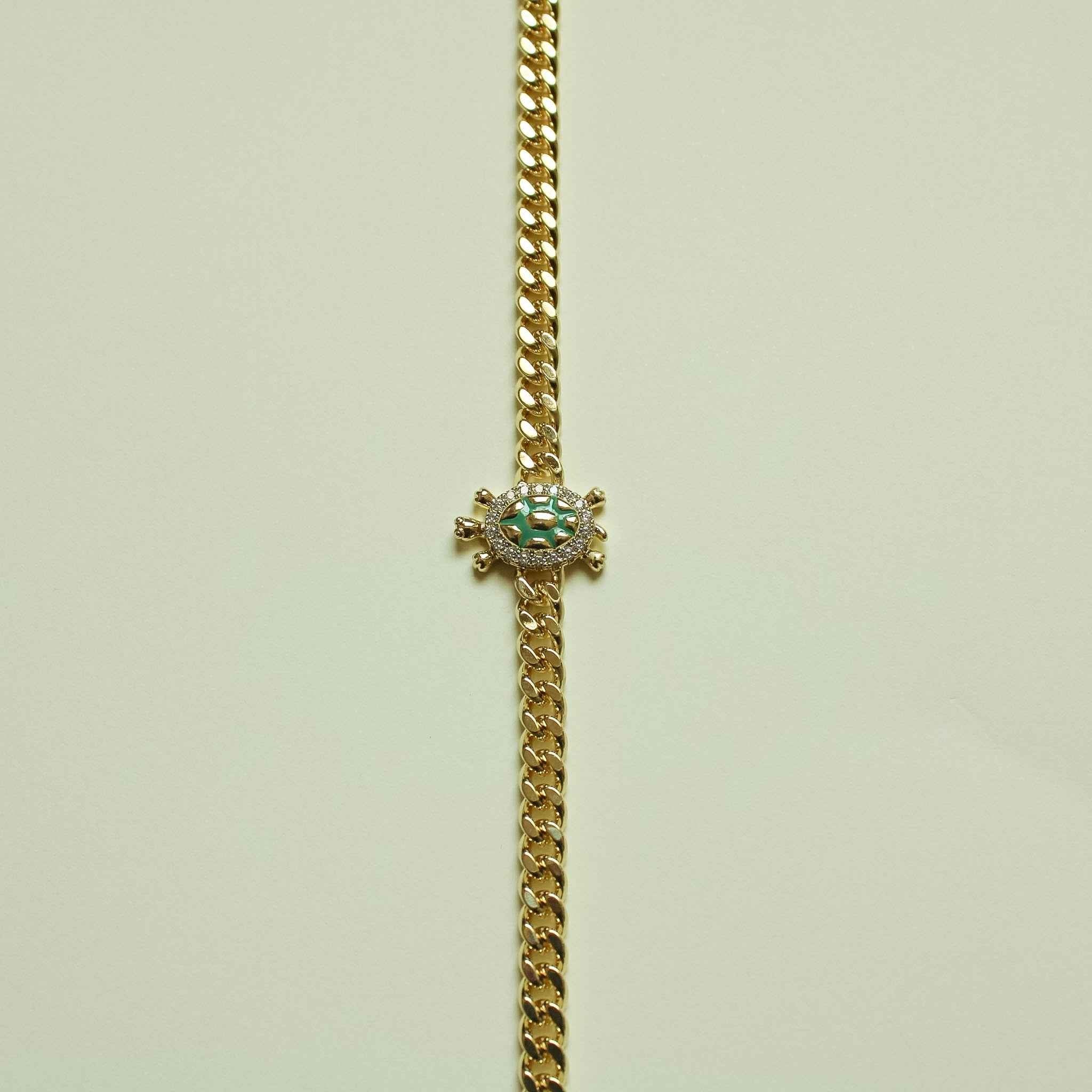 Gold turtle charm pendant on Cuban chain necklace with green enamel center