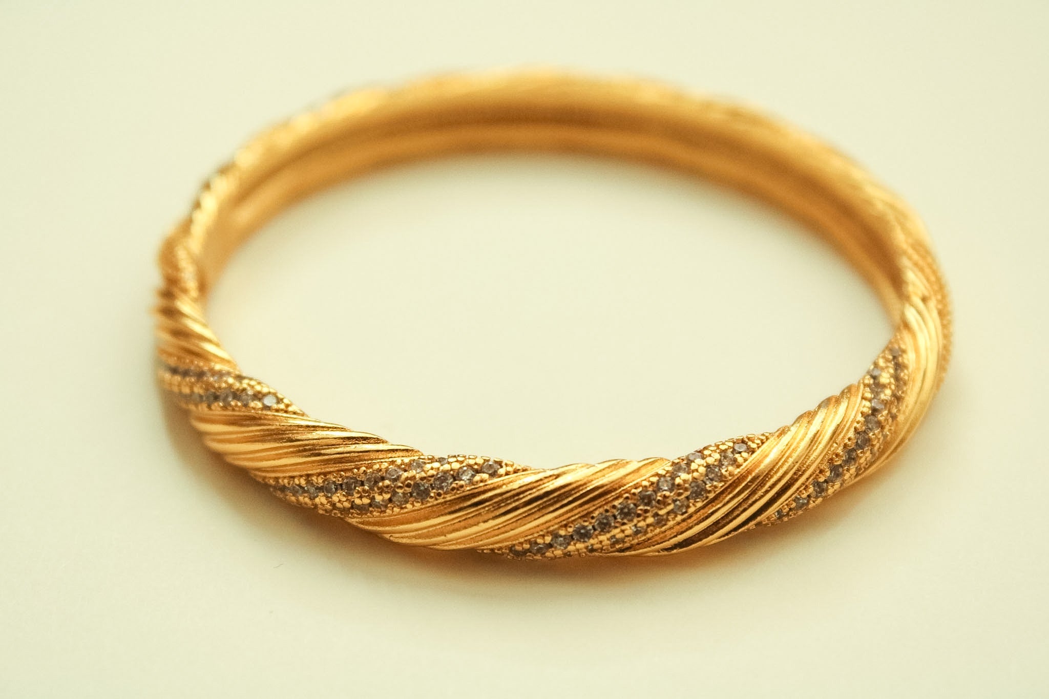22K gold twisted pavé bangle bracelet with CZ accents