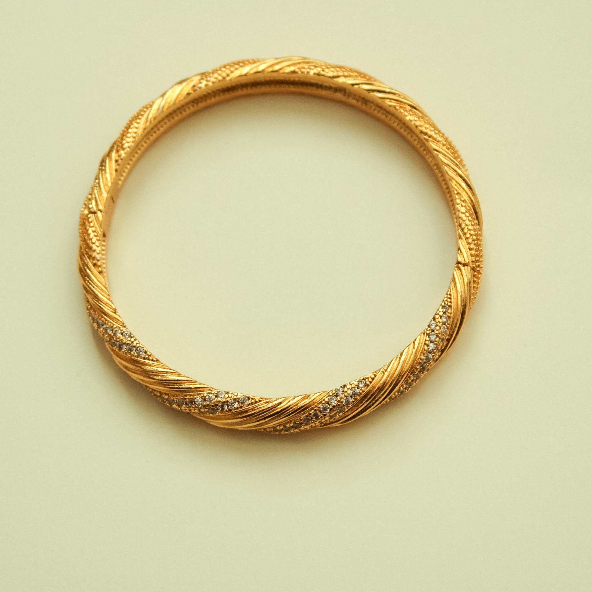 Twisted 22K gold pavé bangle with CZ accents